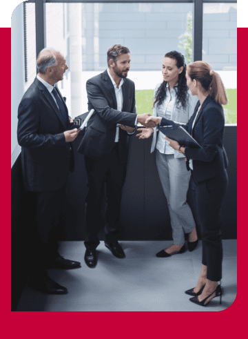 Business professionals shaking hands in a corporate office setting.