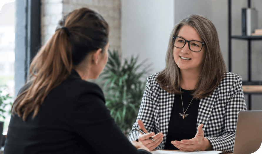Two women having a professional discussion in an office setting.