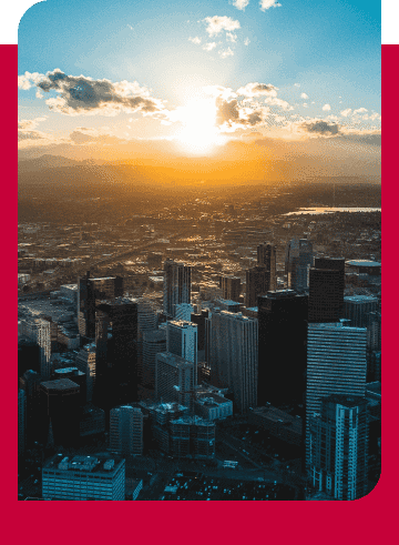 Denver cityscape with sunset sky and high-rise buildings.