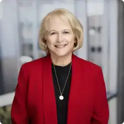 Confident businesswoman smiling in modern office setting.