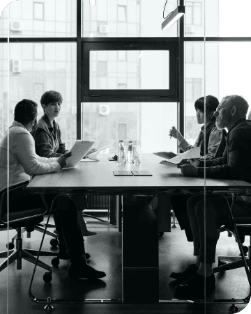 Business meeting with five professionals in a modern conference room.