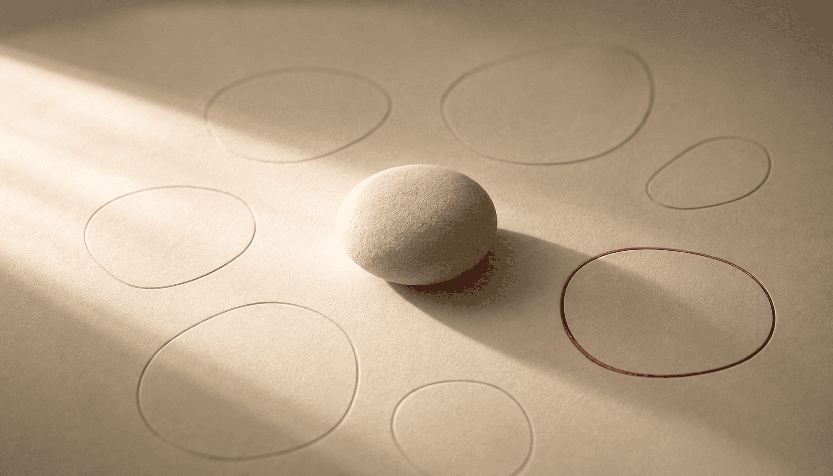 Smooth stone on paper with hand-drawn circles, symbolizing decision-making.