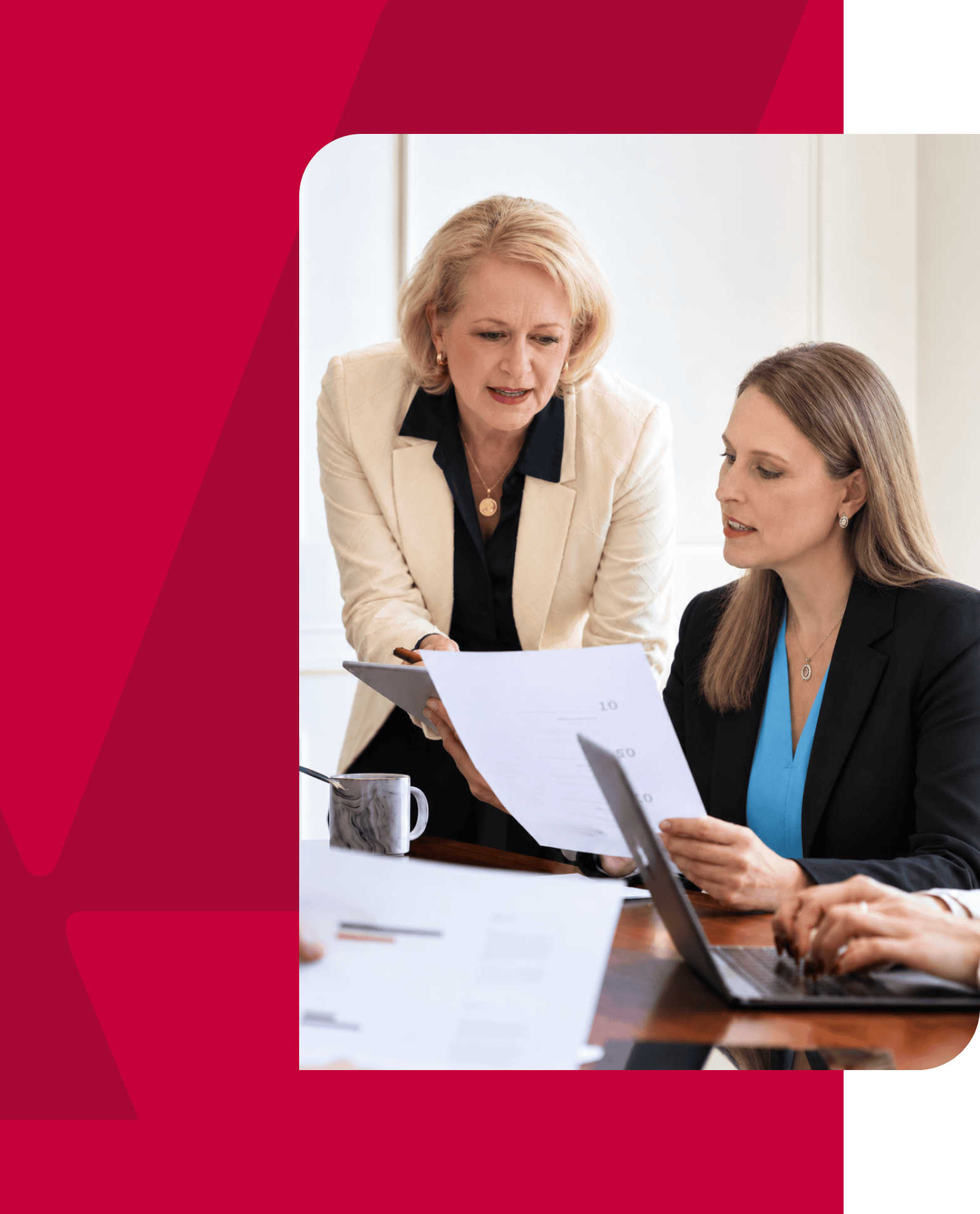 Businesswomen discussing strategy during a meeting in an office setting.