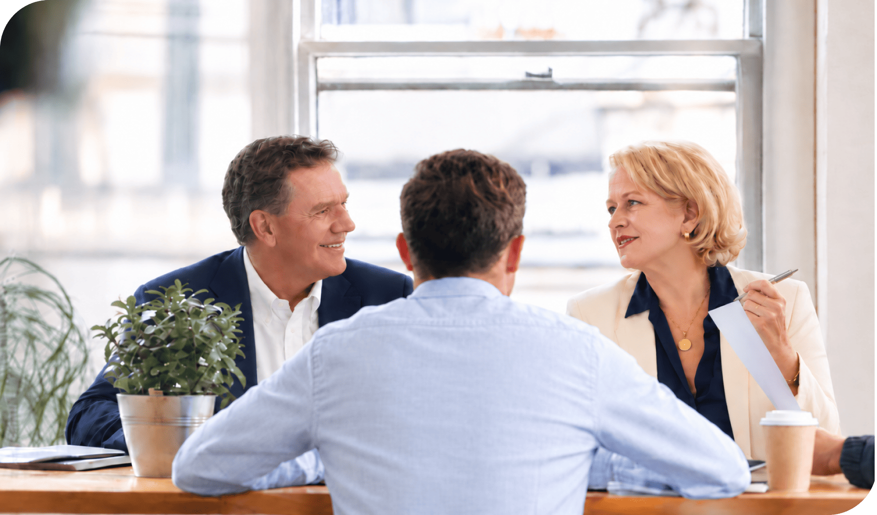 Business professionals engaged in a discussion at a modern office table.