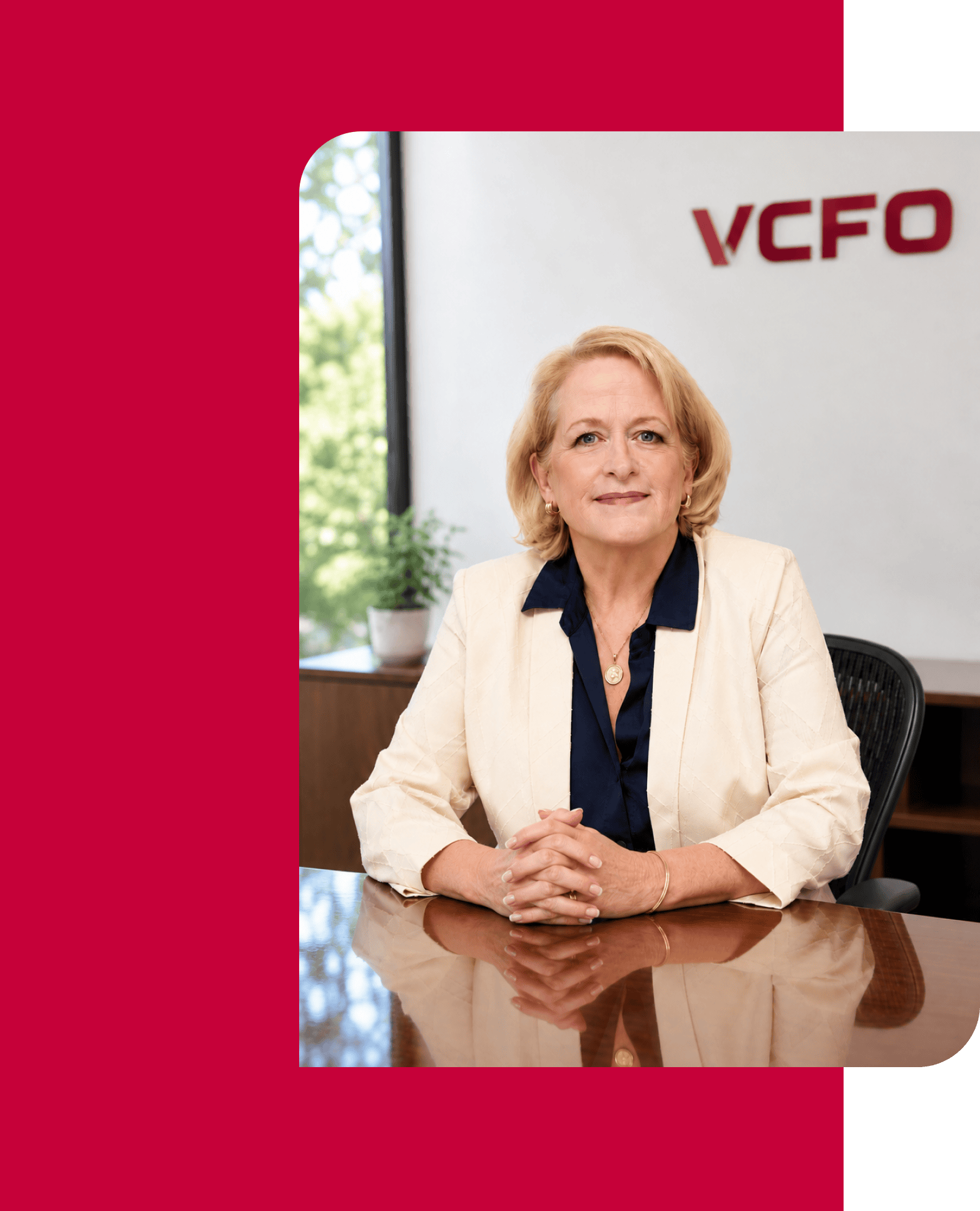 Professional woman at VCFO office with company logo in background.