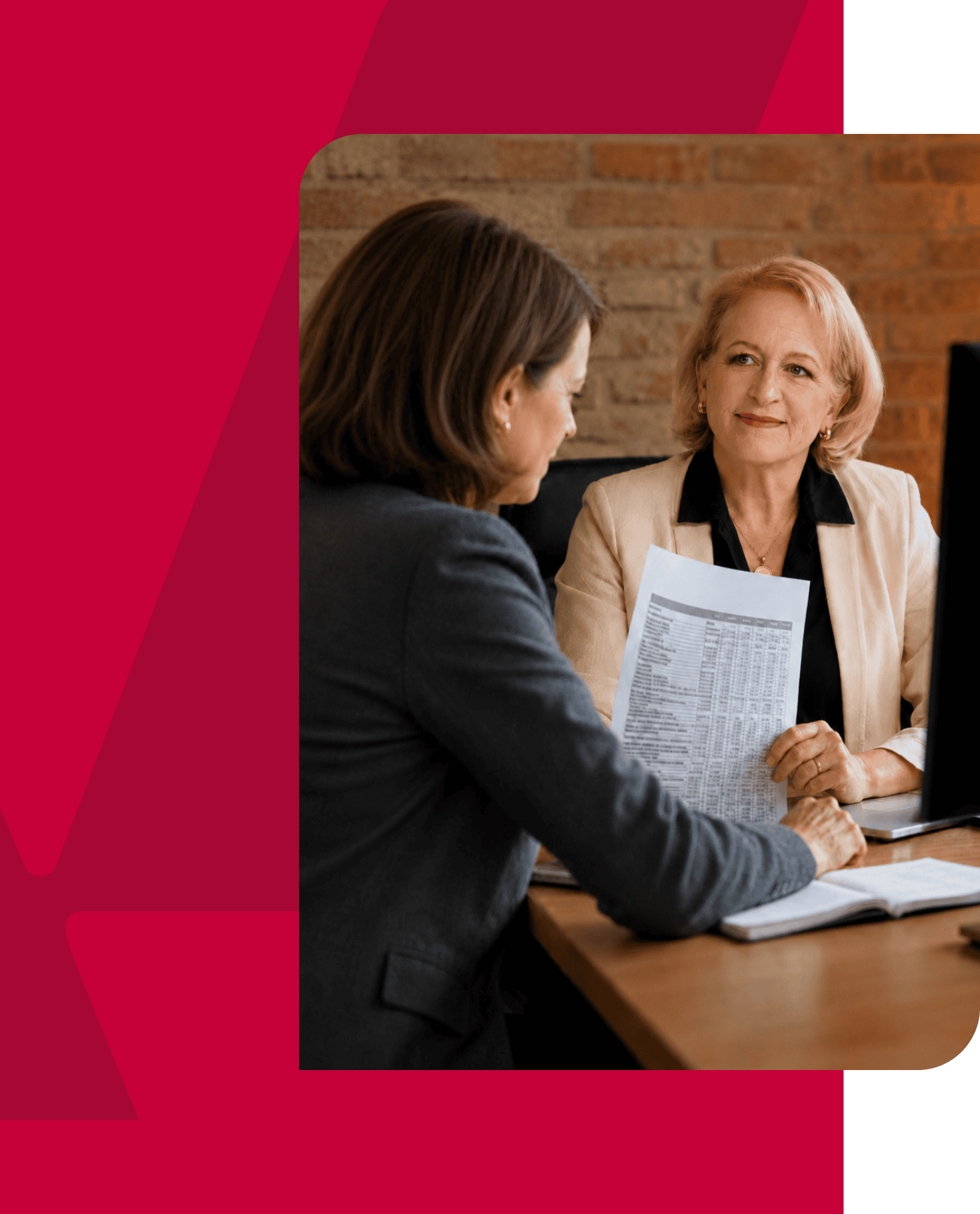 Businesswomen discussing financial documents in an office setting.