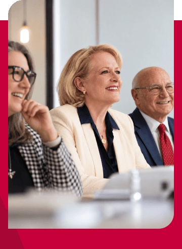 Business professionals attending a meeting, smiling and engaged.