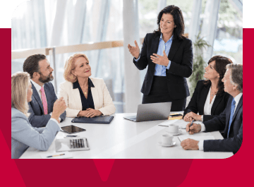 Businesswoman presenting to a diverse group of professionals in a modern conference room.