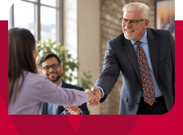 Business professional handshake during a client meeting in an office setting.