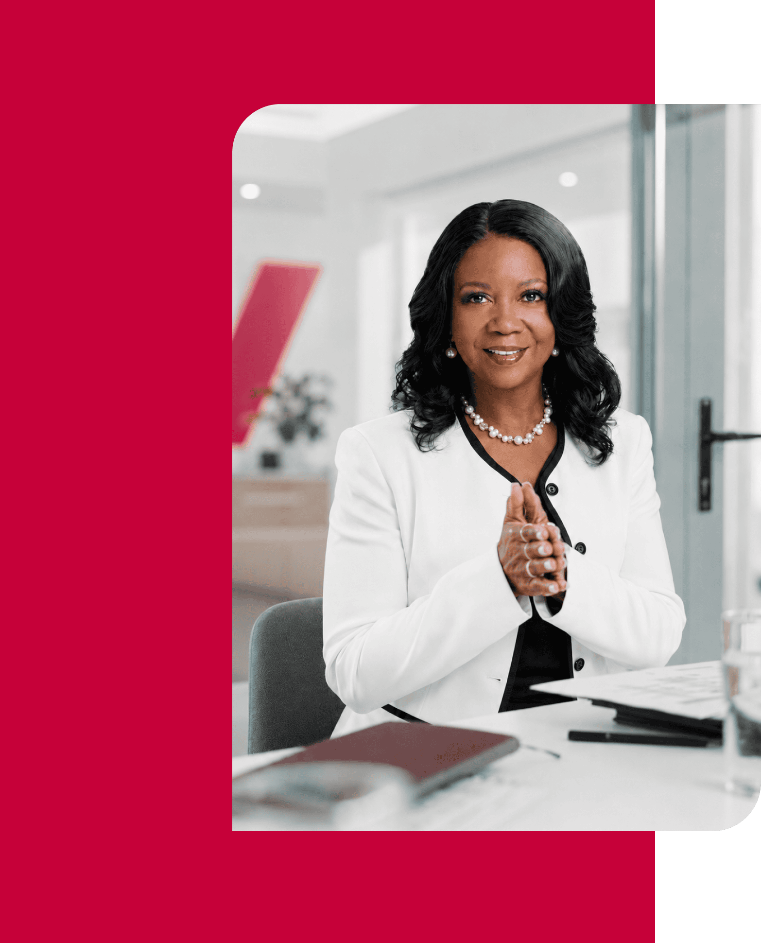 Professional woman in business attire smiling in a modern office setting.
