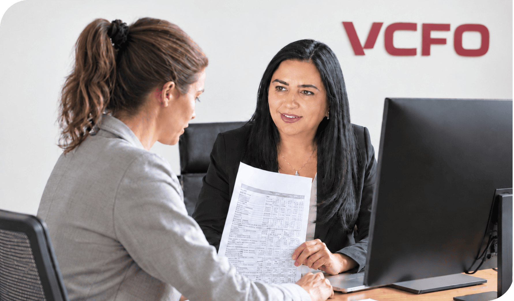 Business meeting at VCFO office discussing financial documents and strategies.