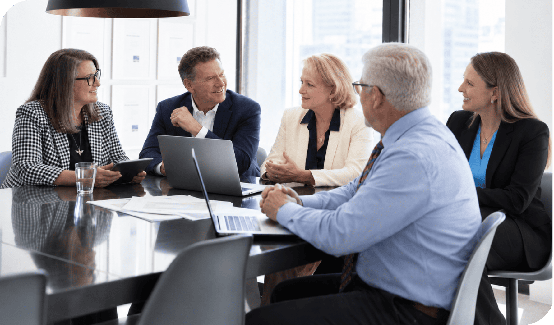 Business professionals in a meeting discussing strategies at a modern office conference table.
