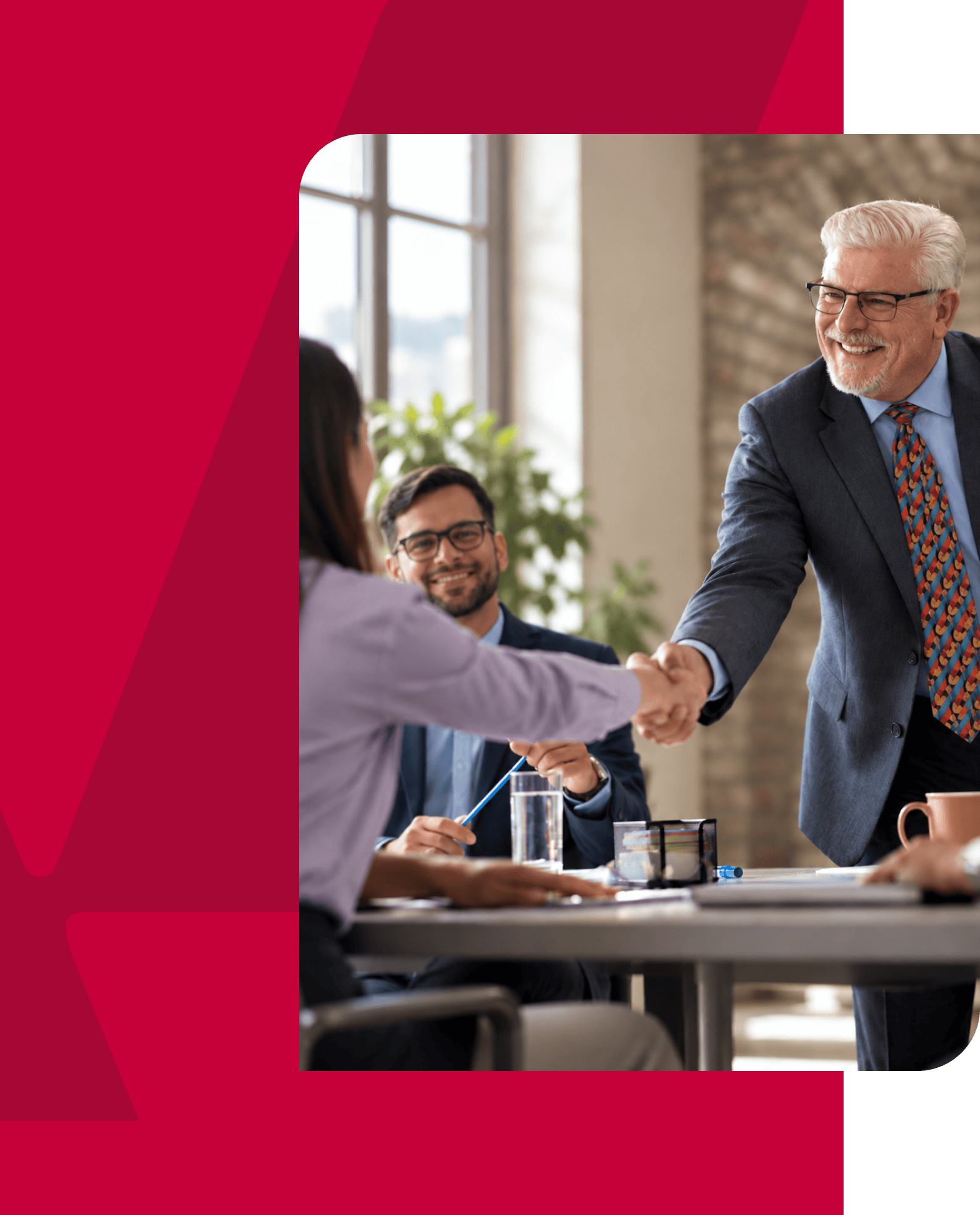 Business professionals shaking hands in a modern office setting.