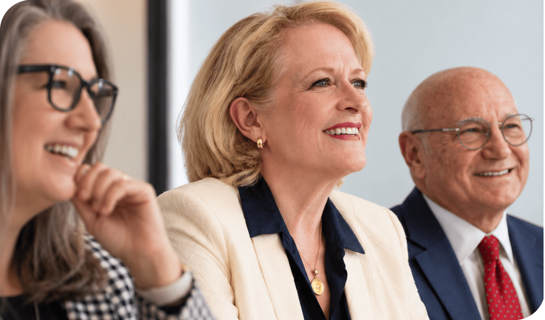 Business professionals smiling during a meeting or conference.