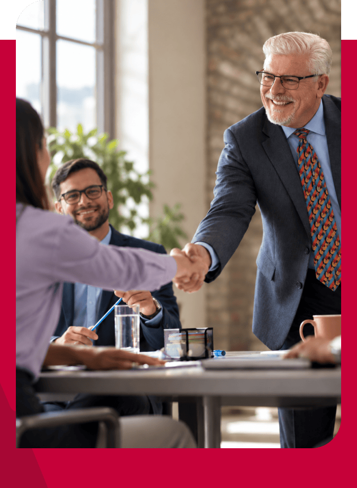 Business handshake between senior man and woman in a professional meeting.