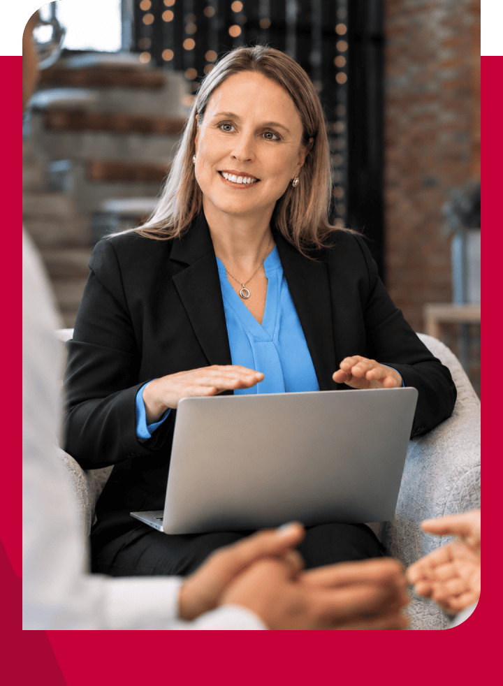 Businesswoman in a professional setting with a laptop during a meeting.