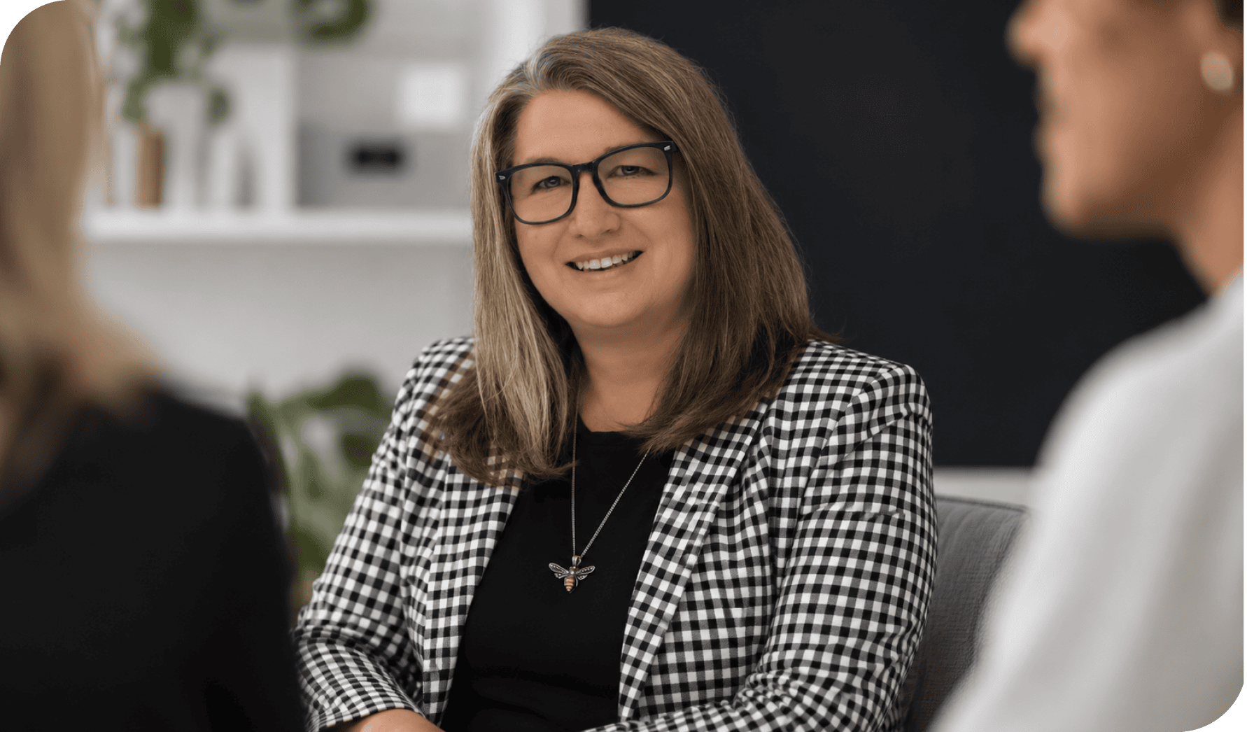 Businesswoman smiling during a professional meeting in an office setting.