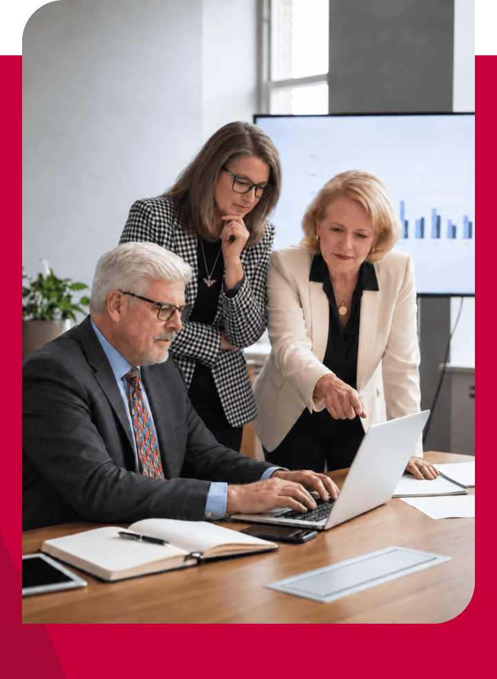 Business team analyzing data on a laptop during a meeting.