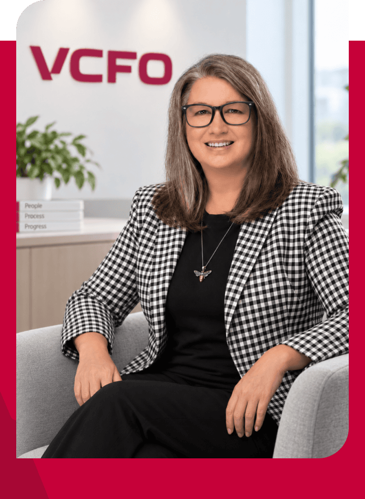 Professional woman in office with VCFO logo in background.