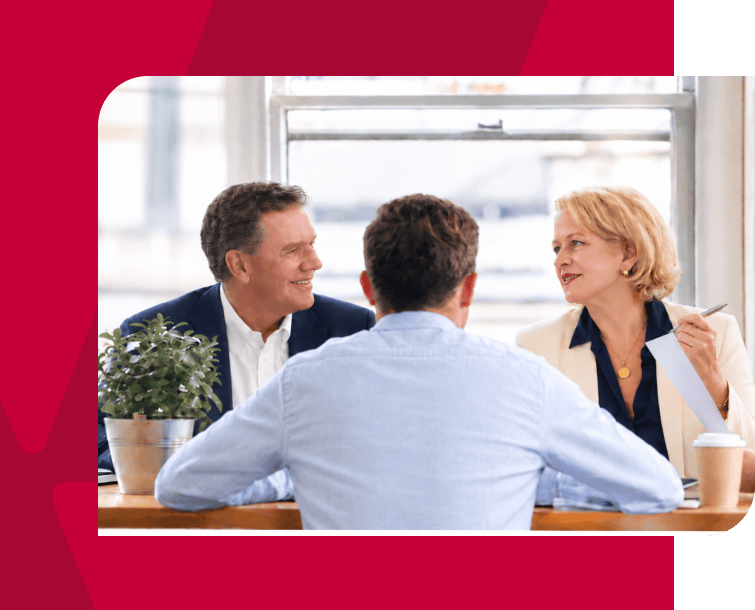 Business meeting with three professionals discussing strategies at a modern office.