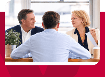 Business professionals engaged in a discussion at a modern office table.