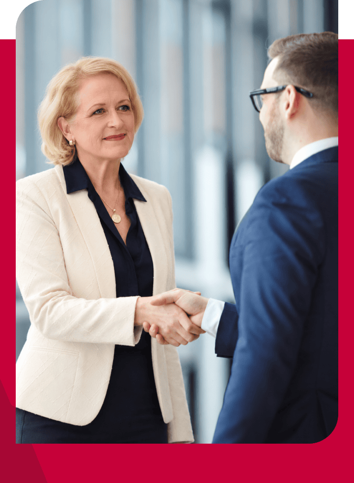 Business professionals shaking hands during a meeting in a modern office.